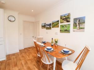 a dining room with a wooden table and chairs at Daisy Cottage in Leyburn