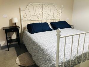 una camera da letto con un letto bianco con cuscini blu e un tavolo di Casa delle Rose in centro a Latina