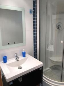 a bathroom with a white sink and a shower at Playa Norte 7ºG in Peniscola +8 photos