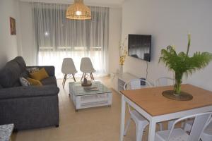 a living room with a couch and a table at La Caparina, apartamento con piscina a 3 km de la playa in Llanes
