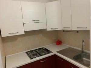a kitchen with white cabinets and a stove and a sink at Eden MONOLOCALE Torre dell Orso in Torre dell'Orso +11 photos