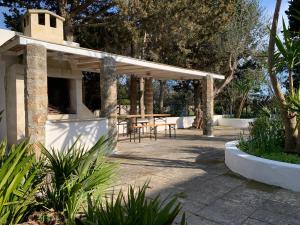 a patio with a table and some trees at Eden MONOLOCALE Torre dell Orso in Torre dell'Orso