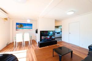 a living room with a tv and a table and chairs at HOUSE K in Ichinomiya
