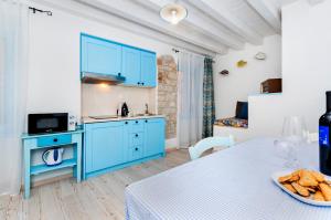 a kitchen with blue cabinets and a table with a bowl of bread at Apartments & Rooms La casa Barbaro in Rovinj