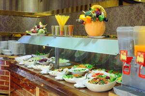 una línea de buffet con muchos platos de comida. en Zowar International Hotel en Medina