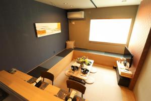 a meeting room with two tables and a projection screen at ORIGAMI STAY -Futatsubashicho- in Nagoya