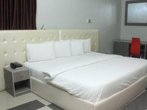 Room in Lodge - Ambience Hotel and Suites-magodo, tesisinde bir odada yatak veya yataklar