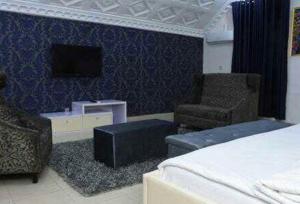 Room in Lodge - Ambience Hotel and Suites-magodo, tesisinde bir oturma alanı