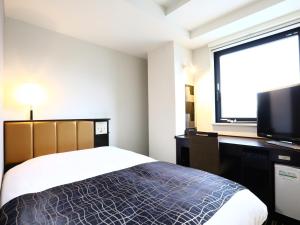 APA Hotel Ginza Shintomicho Ekimae في طوكيو: غرفة نوم بسرير وتلفزيون بشاشة مسطحة