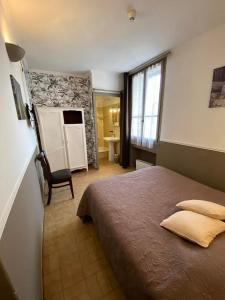 サン・ジルにあるHôtel Restaurant Le Saint Gilloisのベッドルーム(大型ベッド1台付)、バスルームが備わります。