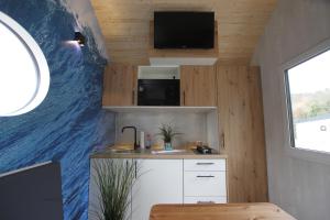 a small kitchen with a large wave mural on the wall at Tiny Wave Tiny House auf dem Campingplatz Strandgut in Cuxhaven