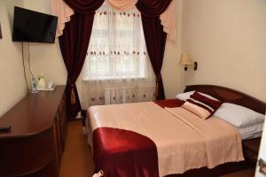 a bedroom with a bed and a dresser and a window at Hotel in Votchina Deda Moroza in Velikiy Ustyug