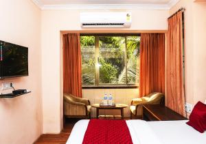 a hotel room with a bed and a window at Hotel Subhash- Andheri in Mumbai