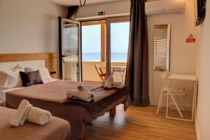 a bedroom with two beds and a view of the ocean at The Wave Baleal in Baleal