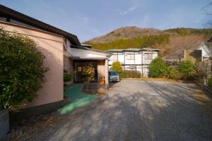 a driveway of a house with a mountain in the background at David no Yakata in Yufuin