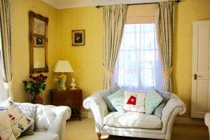 uma sala de estar com um sofá e uma janela em Seaside Luxury House on the Suffolk Coast em Saxmundham