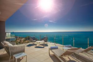 a balcony with chairs and a view of the ocean at Blue Line Apartment Hotel in Villajoyosa