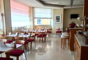a restaurant with wooden tables and red chairs at Hotel Riviera in Segrate