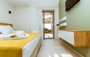 a bedroom with a large bed with a yellow blanket at Iliovasilema Apartments in Elafonisi