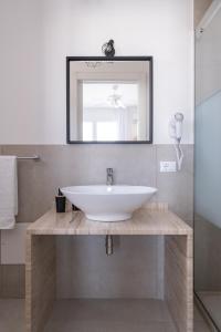 bagno con lavandino bianco e specchio di B&B Villa Sara a San Vito lo Capo