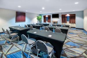 a conference room with tables and chairs and a tv at Microtel Inn & Suites Columbus North in Columbus