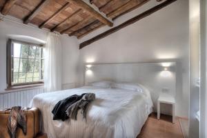 a bed sitting in a room next to a window at Salvadonica in San Casciano in Val di Pesa