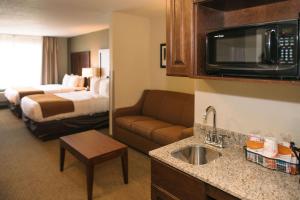 a kitchen with a coffee table and a microwave at Comfort Inn & Suites Near Custer State Park and Mt Rushmore in Custer