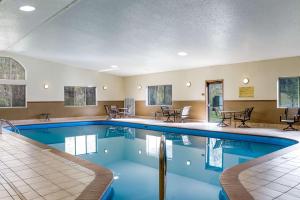 カスターにあるComfort Inn & Suites Near Custer State Park and Mt Rushmoreのテーブルと椅子付きのホテル内のプールを利用できます。