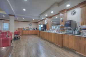 カスターにあるComfort Inn & Suites Near Custer State Park and Mt Rushmoreのレストラン(赤い椅子のあるバー付)