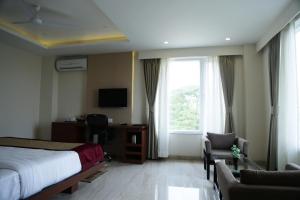 a hotel room with a bed and a desk and a window at Hotel Prism - A Boutique Hotel in Jorhāt
