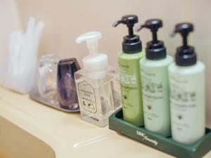 a group of bottles of soap and toothpaste on a bathroom counter at Hotel AreaOne Miyazaki in Miyazaki