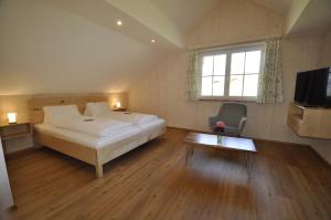 1 dormitorio con cama, mesa y TV en Ferienwohnungen Holzidylle en St. Wolfgang