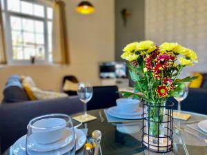 a vase of flowers sitting on a glass table at 4 Single beds or 2 Doubles - FREE PARKING SPACES - SMART TV's - City Centre Spacious flat in Southampton +12 photos