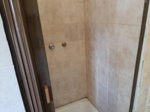 a shower with beige tile in a bathroom at Miami guest house in Vereeniging