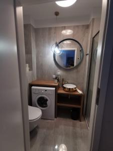 a bathroom with a washing machine and a mirror at Apartment Paula in Świnoujście
