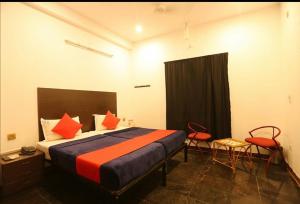 1 dormitorio con 1 cama con almohadas de color naranja y azul en Le Apex Home Stay en Auroville