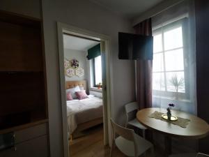 Un dormitorio con una cama y una mesa y una ventana. en Greta, en Świnoujście