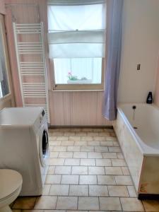 uma casa de banho com uma máquina de lavar roupa e uma janela em Trietje em Gent