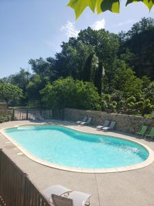 una grande piscina con sedie e recinzione di Le Moulin D'onclaire Camping et chambres d'hôtes a Coux