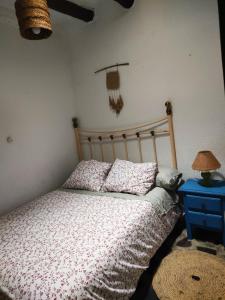 a bedroom with a bed and a table with a lamp at La Maestra in Trevélez