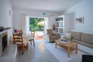 ein Wohnzimmer mit einem Sofa und einem Tisch in der Unterkunft Quinta Paraiso da Mia - 1 Bedroom Apartment in Luz