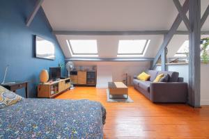 ein Schlafzimmer mit einem Bett und ein Wohnzimmer mit Fenstern in der Unterkunft L'escale Nemourienne in Nemours
