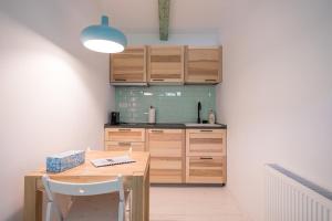 a kitchen with wooden cabinets and a wooden table at Hygge Hut in Vama