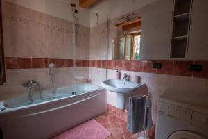 a bathroom with a tub and a sink and a toilet at Happy Guest Apartments - Feel The Lake in Riva di Solto +5 photos