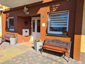 two benches sitting outside of a building with a window at Willa u Anny in Mielno