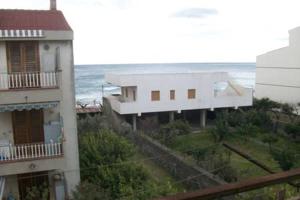 vista su due edifici con l'oceano sullo sfondo di ColourHouse a Furci Siculo