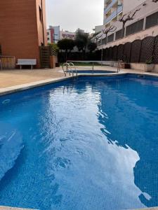a large blue swimming pool in front of a building at SeaHomes Vacations, FENALS BEACH&CHIC, pk, top apartment full equipped in Lloret de Mar