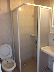 a bathroom with a shower with a toilet and a sink at Marigold hostel in Çeşme