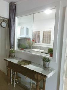 uma casa de banho com um lavatório e uma janela com vasos de plantas em CHAMBRES D'HÔTES CHEZ CATHERINE A REUS chambre bord de mer avec salle de bains privée em Reus