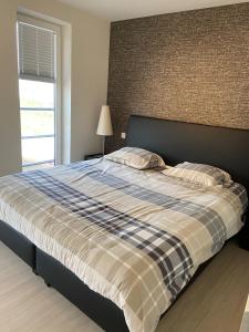 a bedroom with a bed with a plaid blanket and a window at Chantal in Brun Culot